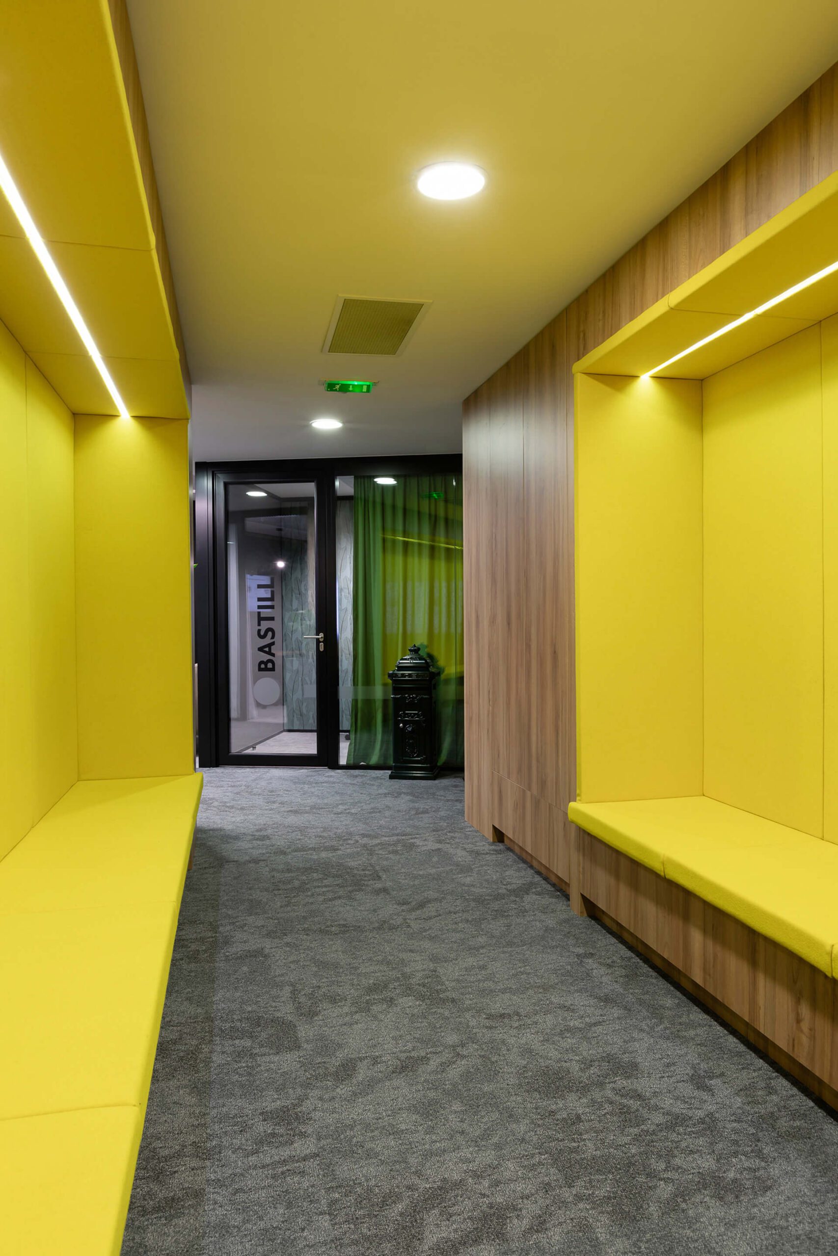 corredor com bancos embutidos amarelos e em madeira